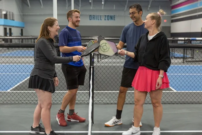 Group of four pickleball players get ready to start a new game